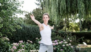 Frau in der Kriegerposition beim Yoga im Garten des Hotel Antoniushof – Balance und Achtsamkeit in der Natur