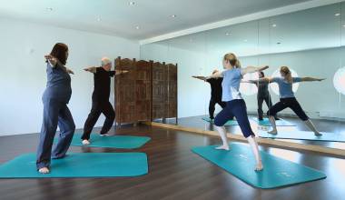 Menschen bei Yoga-Übungen in einem modernen Kursraum