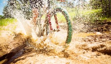 Fahrrad fährt durch Schlammpfütze
