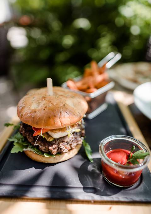 Ein leckeres Gericht aus Burger, Süßkartoffelpommes und Ketchup, serviert im Restaurant.