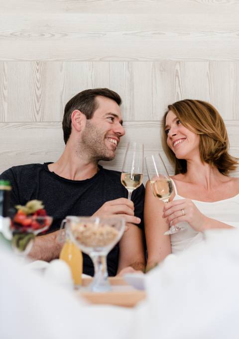 Romantisches Paar genießt Sekt im Bett im Antoniushof