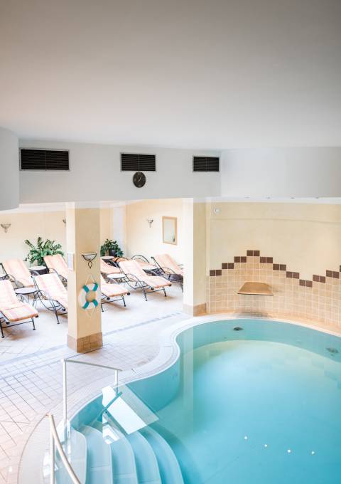 Indoorpool mit Liegestühlen und entspannter Atmosphäre im Antoniushof