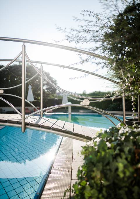 tilvolle Brücke führt über den Außenpool mit Sonnenschein