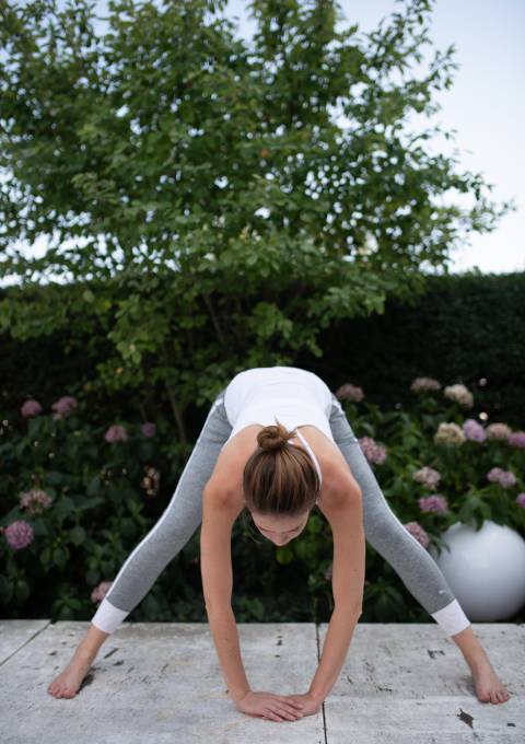 Frau praktiziert Yoga im Garten des Hotel Antoniushof – Achtsamkeit und Entspannung in der Natur