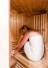 Frau sitzt mit Handtuch in der Infrarot Sauna im Antoniushof