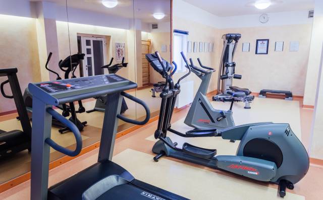 Fitnessraum mit Laufbändern, Crosstrainer und Kraftgeräten