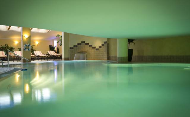 Beheizter Indoor-Pool mit angenehmer Beleuchtung und Liegebereich