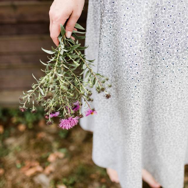Frau hält Blumen in der Hand im Garten des Antoniushof