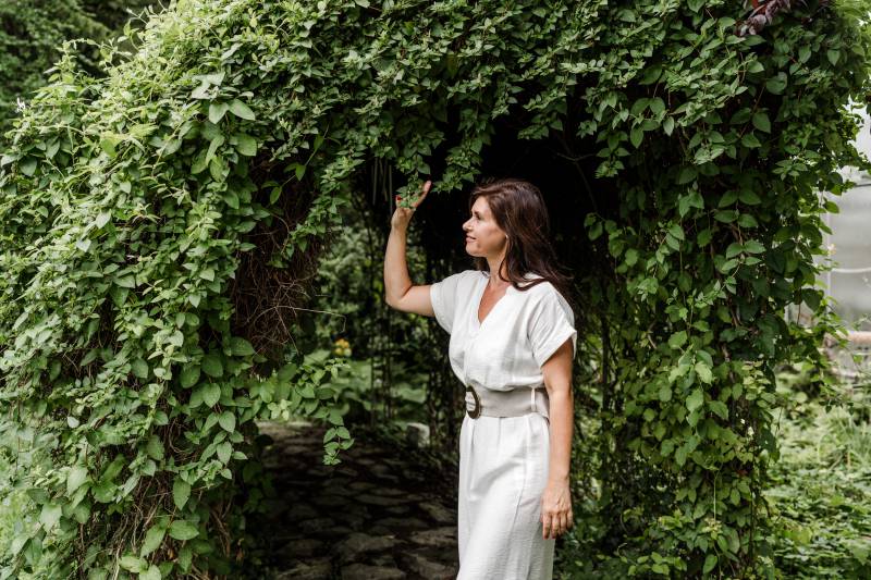 Gast im Garten des Antoniushofs unter einem bewachsenen Torbogen in ruhiger Umgebung