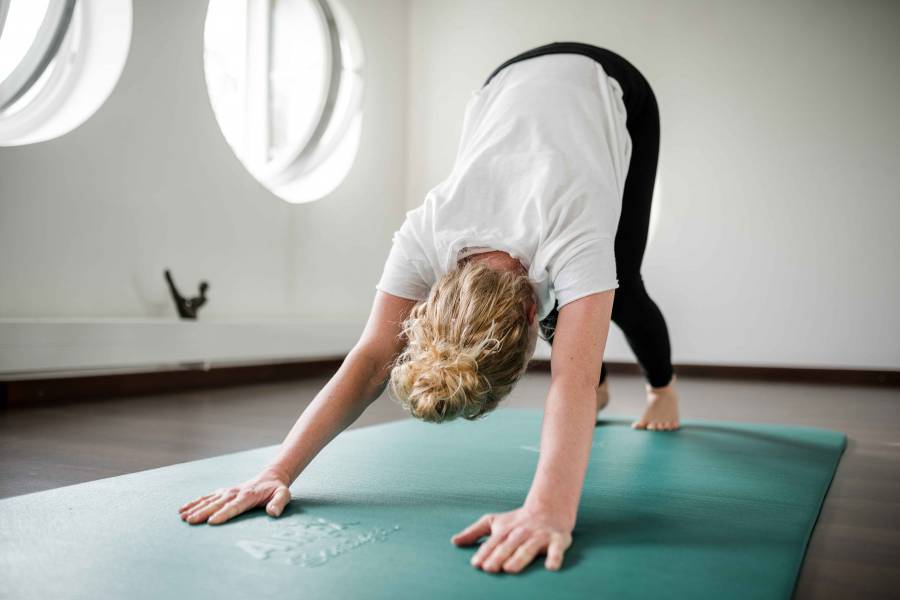 Gast in der Yogaübung herabschauender Hund während einer Yogaeinheit im Antoniushof Wellnesshotel in Bayern