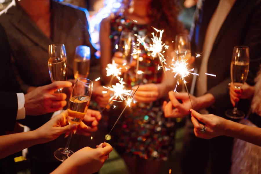 Gäste stoßen im Antoniushof mit Sekt an und halten funkelnde Wunderkerzen – festliche Stimmung beim Silvesterurlaub in Bayern